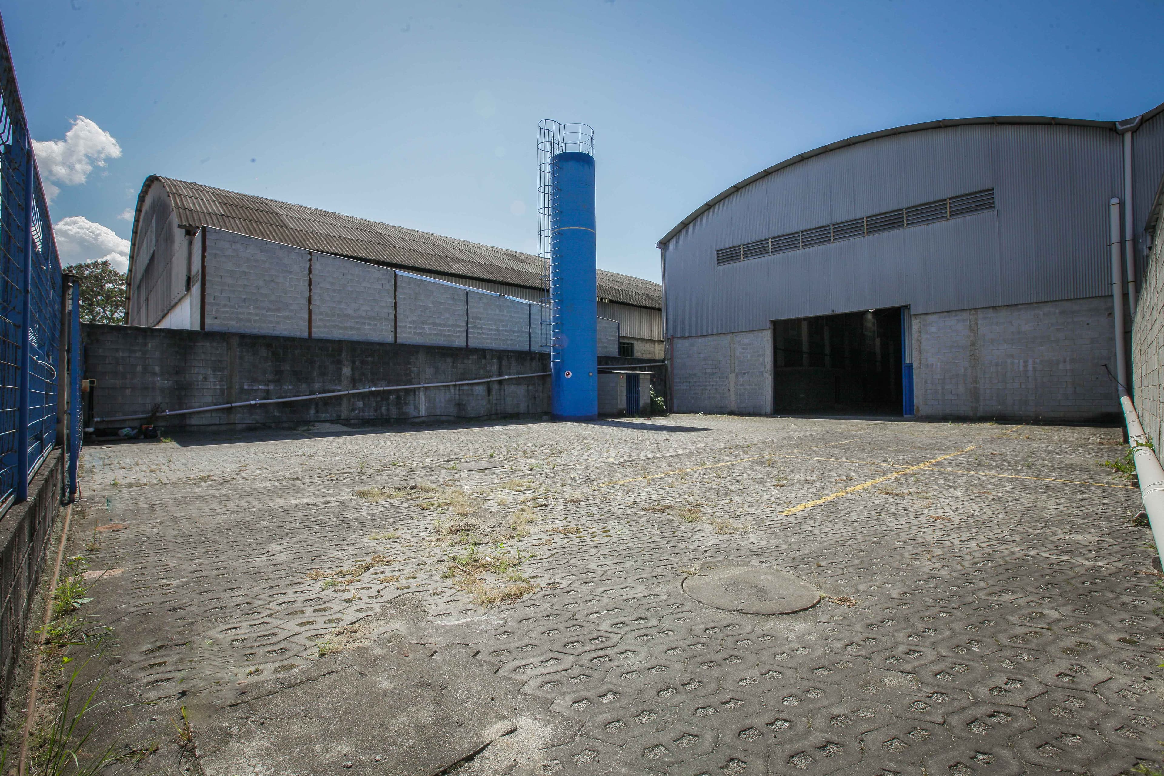 Pátio pavimentado e fachada em arco do galpão industrial em Jardim Limoeiro
